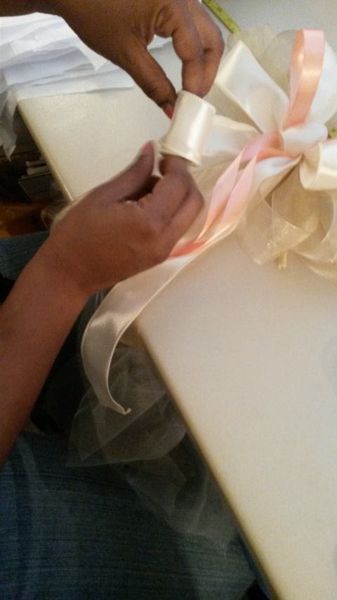 If the bow tails are curled in the product photo,  I make sure top re-curl the tails and secure them with tape.  When the bride removes the tape,  the tails will be curried and ready to go!